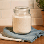 A jar of pancake dry mix on some linen sitting on a wooden bench by farmer's wife homestead