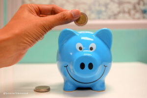 blue money box with a coin being placed in it