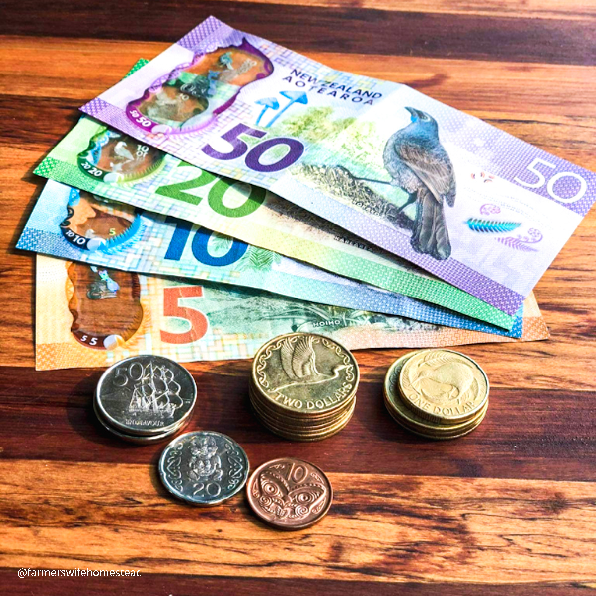 nz money and coins on a wooden board