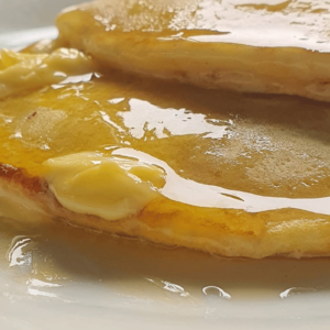 Two fluffy pancakes with melting butter ontop