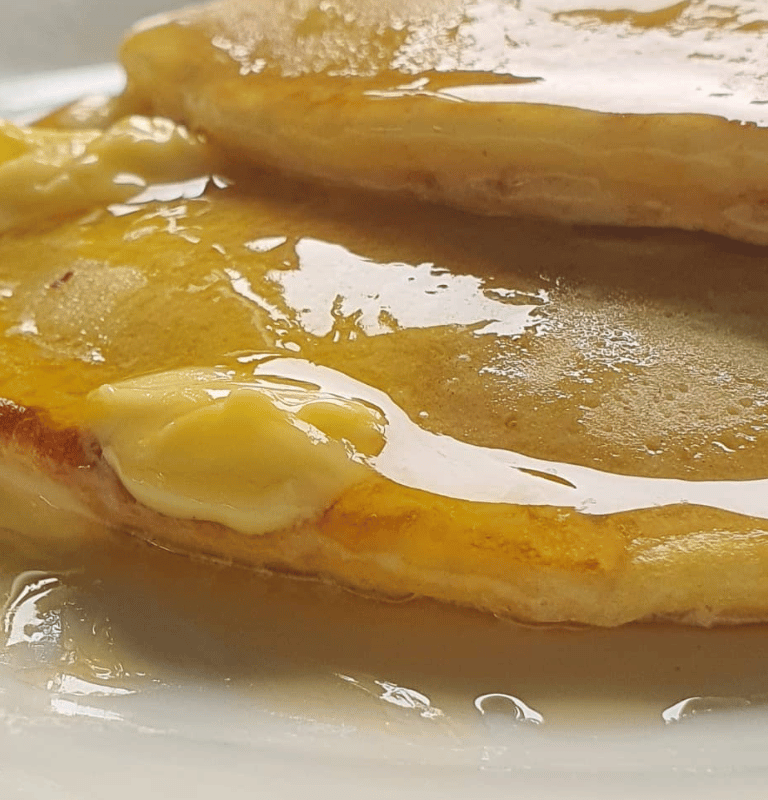 Two fluffy pancakes with melting butter ontop