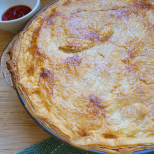 finished pie with a side of tomato sauce