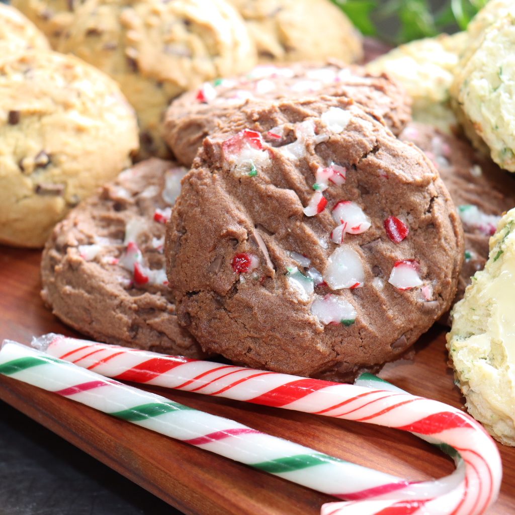 Double chocolate Christmas cookies sitting on a board with candy canes