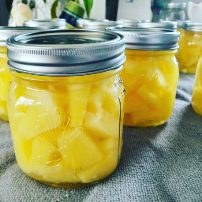 Jars of pineapples sitting on a bench