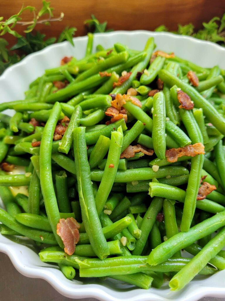 a plate of green beans with crispy bacon