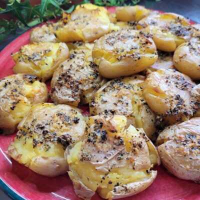 smashed cooked crispy potatoes with a garlic and herb butter over top