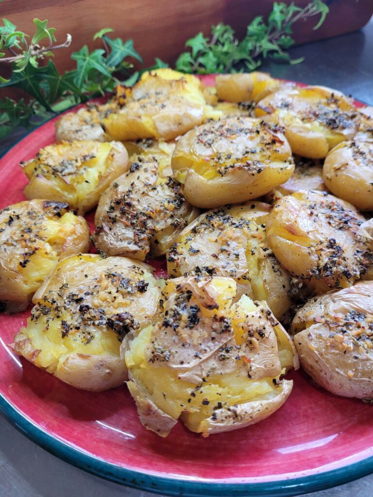 smashed potatoes with garlic and herb butter on a red plate