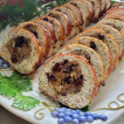 two rows of cranberry stuffed chicken roll on a platter