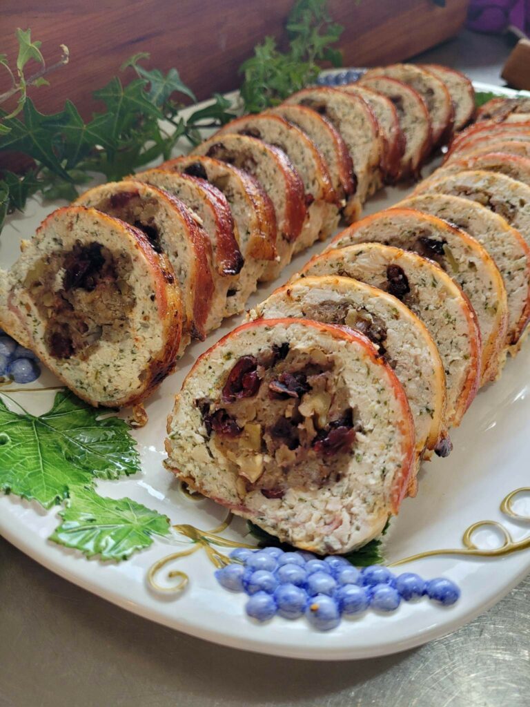 two rows of cranberry stuffed chicken roll on a platter