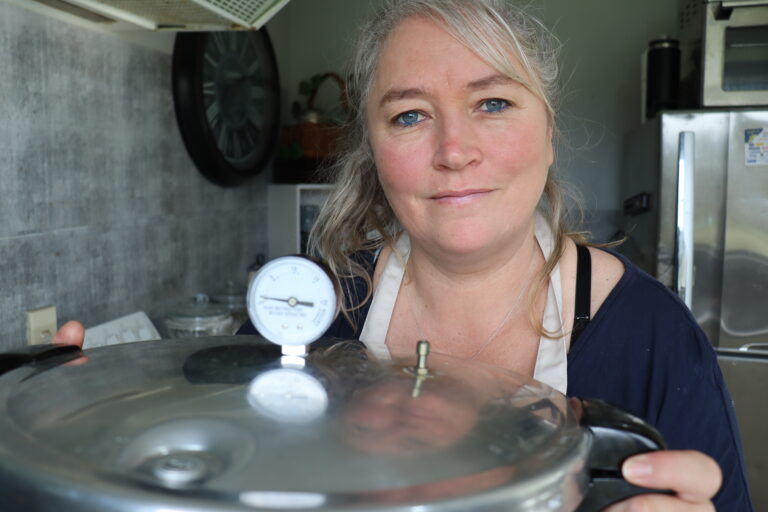 woman holding a pressure canner in a new zealand kitchen