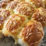 cheese and ham bread rolls on a wooden board