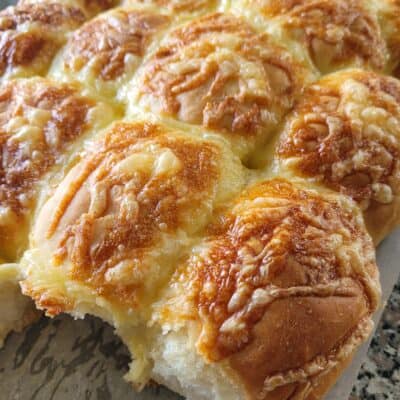 cheese and ham bread rolls on a wooden board
