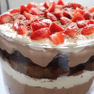 Chocolate cherry trifle in a glass bowl with strawberries on top