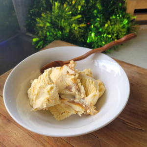 Homemade Salted Caramel Ice cream in a white bowl with a wooden spoon