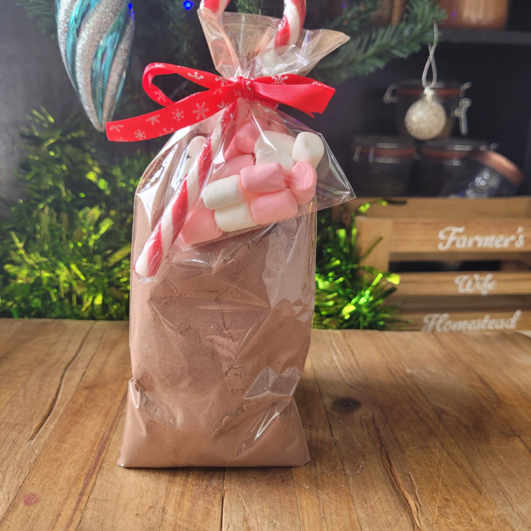 A cellophane bag of hot chocolate mix with a candy cane and mini marshmallows