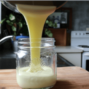 sweetened condensed milk poured into a glass jar. It is nice and thick and creamy