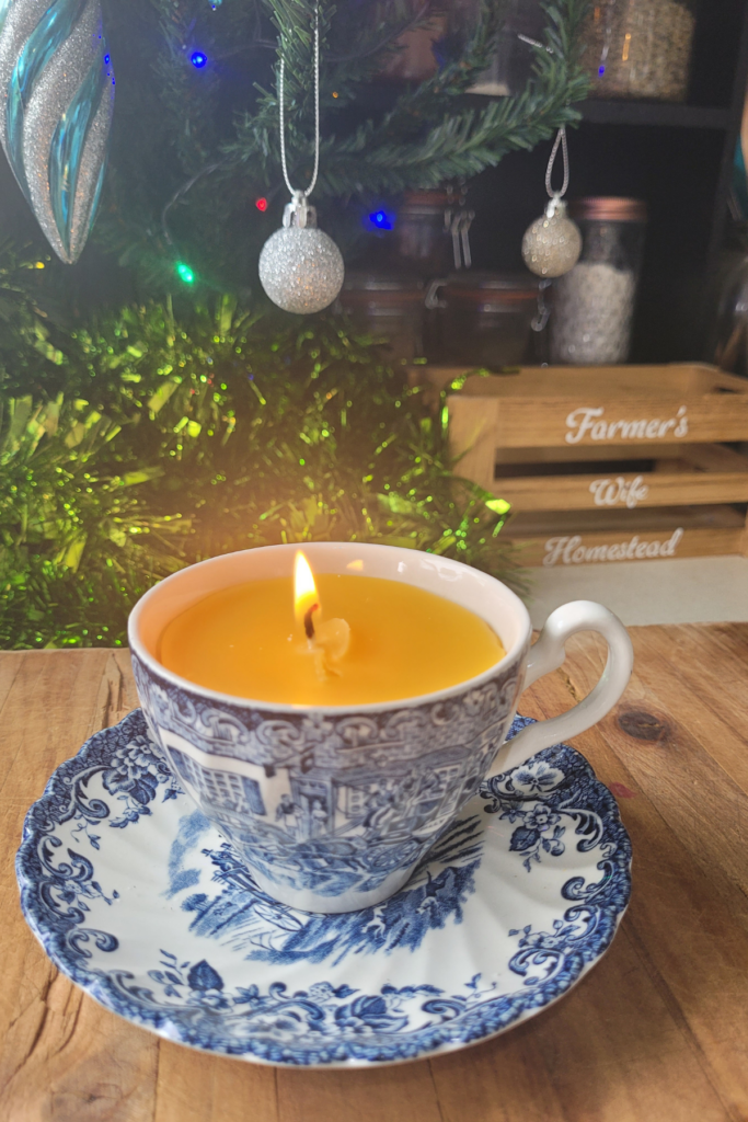 bees wax candle in a blue china tea cup. it has a lovely yellow glow