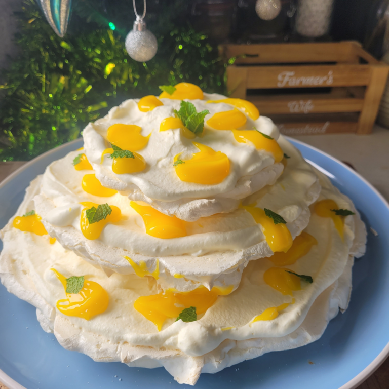 there tier pavlova with lemon curd drops all over it