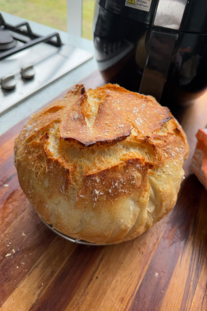 round crusty loaf of bread on a wooden board