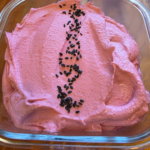 a beautiful pink beetroot and feta dip in a glass container sprinkled with black seeds