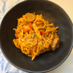 slow cooker creamy sausage and tomato pasta dish in a black bowl
