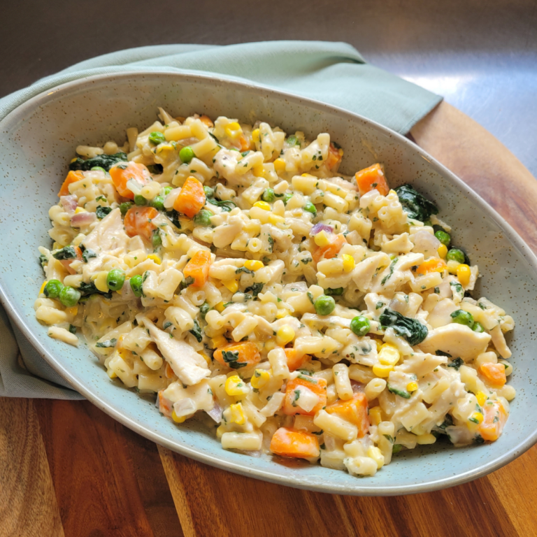 chicken and mixed veggies box mac and cheese in a green oval bowl creamy and cheesy