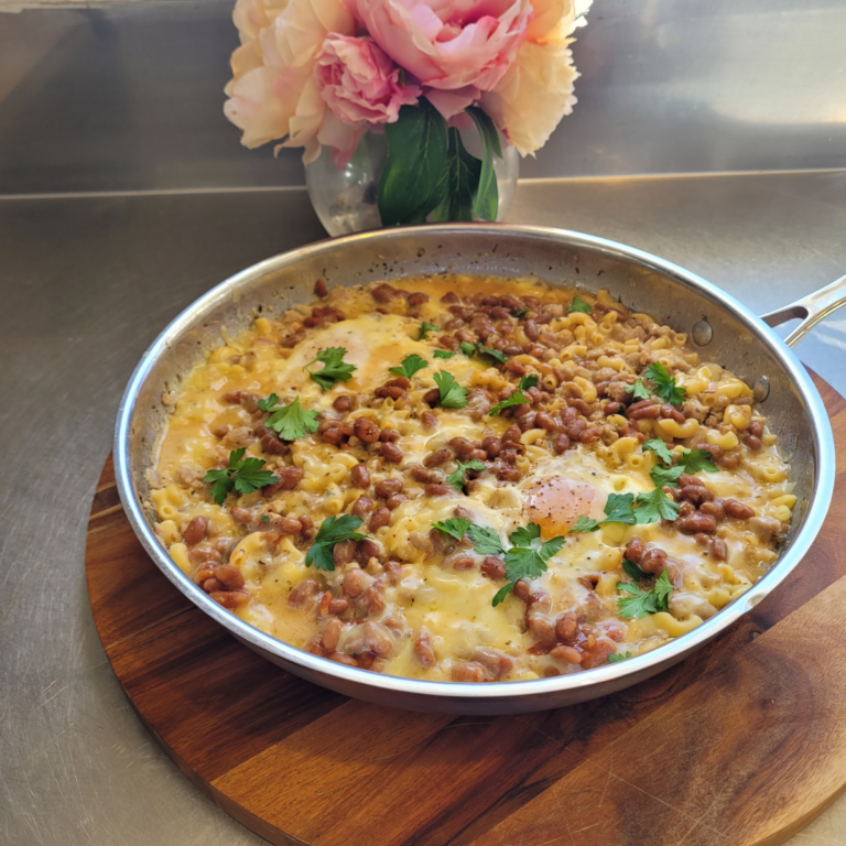 boxed mac and cheese breakfast meal served in a frying pan and topped with poached eggs