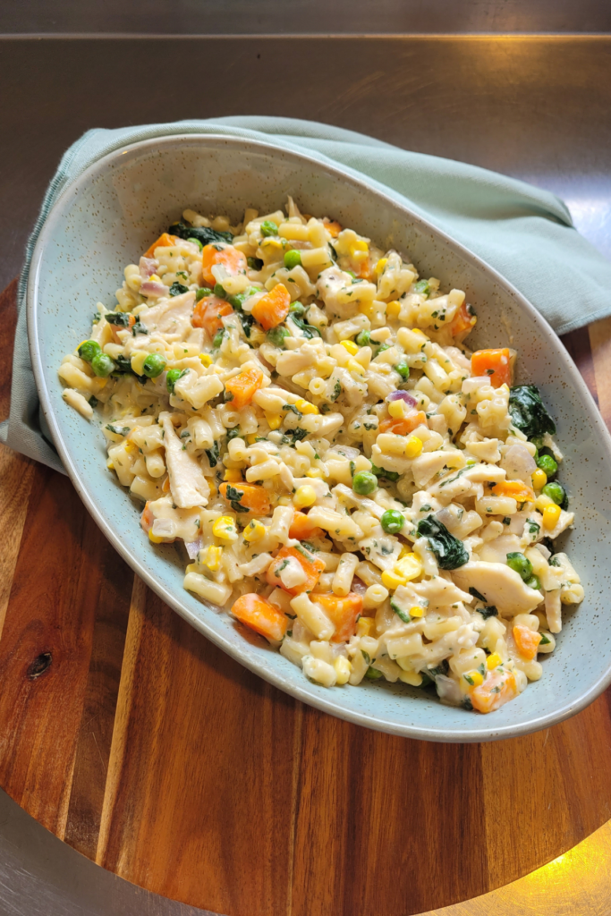 creamy boxed mac and cheese with chicken and veggies in an oval bowl