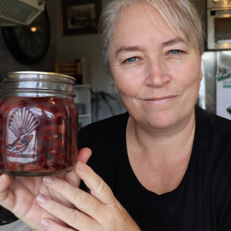 Stacey Farmer's Wife Homestead holding a jar of pressure canned kidney beans