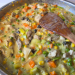 cheats chicken pot pie filling cooking in a frying pan full of lovely fresh vegetables
