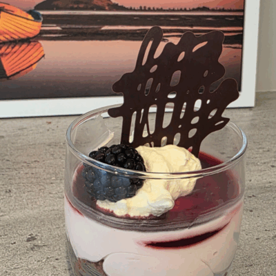 blackberry cheesecake with a chocolate crumb shortbread. in a glass jar and topped with a chocolate shard