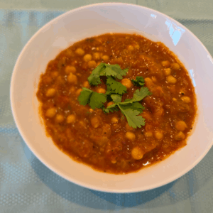 Moroccan lamb in a bowl topped with fresh coriander leaves