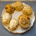 Five flavours of scones on a china plate.