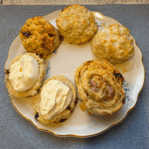 Five flavours of scones on a china plate.