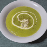 leek and potato soup in a white bowl, with a swirl of cream
