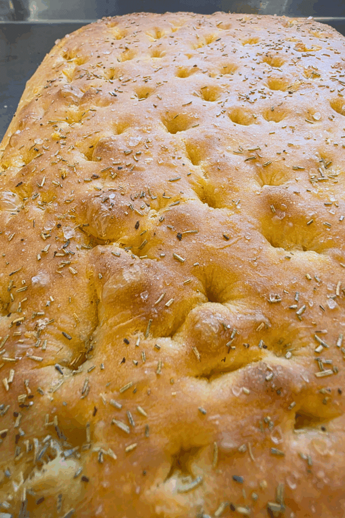 close up of focaccia bread topped with dried rosemary and flakey sea salt