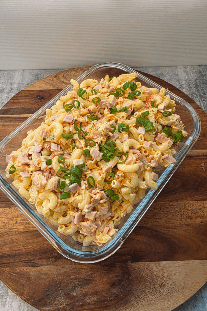glass bowl with Hawaiian macaroni salad topped with ham and spring onions