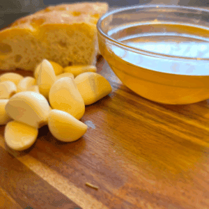 homemade garlic oil in a jar with fresh garlic cloves