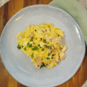 Large serving plate of pasta topped with fresh parsley.