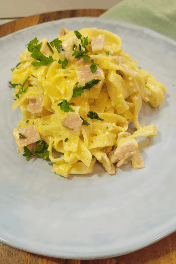 Large serving plate of pasta topped with fresh parsley.