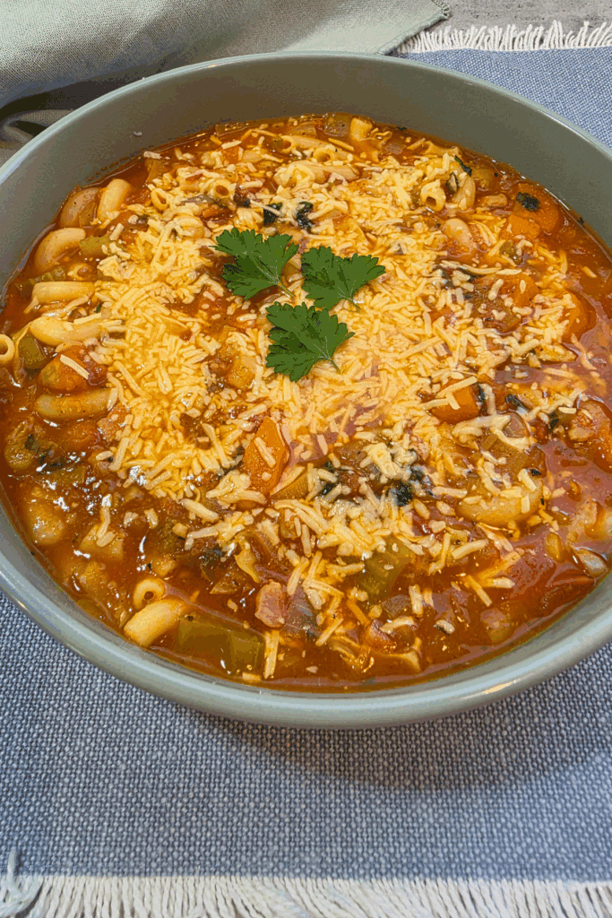 “Bowl of hearty minestrone soup with pasta and beans”