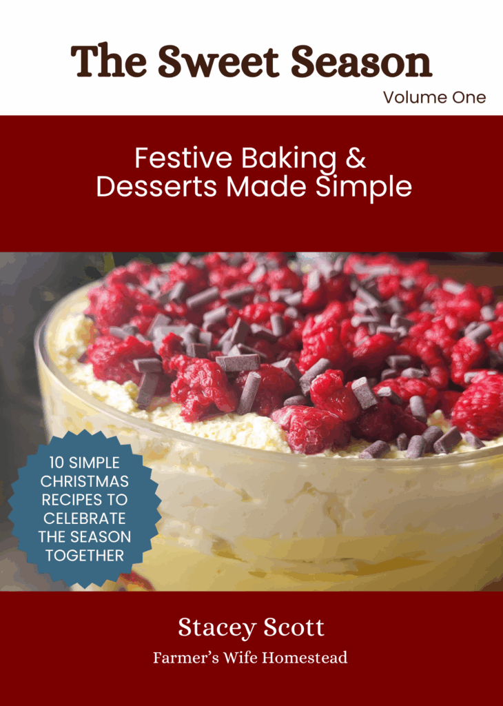 E-book cover titled “The Sweet Season | Festive Baking & Desserts Made Simple, Volume One” by Stacey Scott of Farmer’s Wife Homestead. The design features a trifle dessert layered with cream, custard, raspberries, and chocolate pieces, with a red and white Christmas-themed layout and a blue badge reading “10 Simple Christmas Recipes to Celebrate the Season Together.”