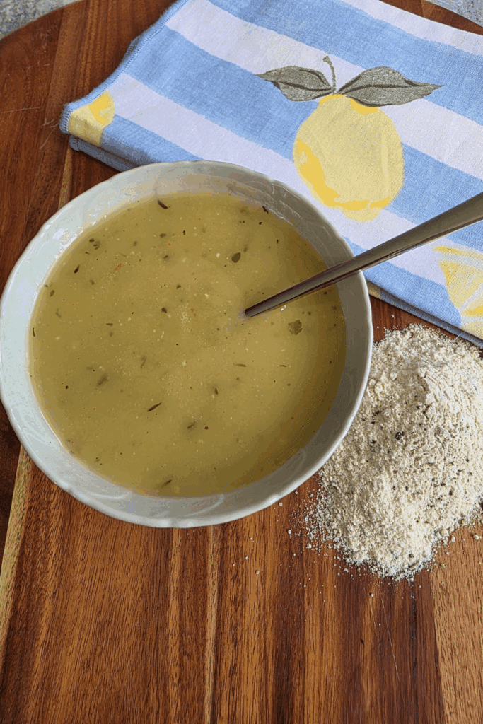 a bowl of chicken gravy and my easy homemade chicken gravy powder. Sitting on a wooden board