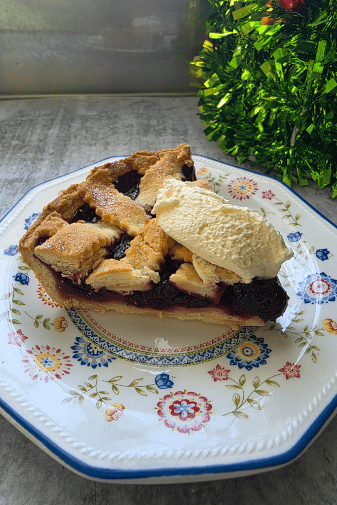 “Slice of festive cherry pie with rich red filling and flaky pastry.”