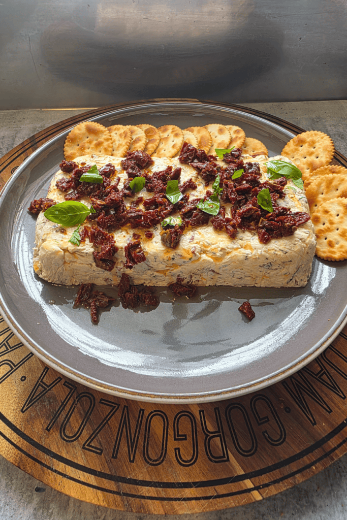 festive farmhouse cheese log. Topped with sundried tomatoes and fresh basil