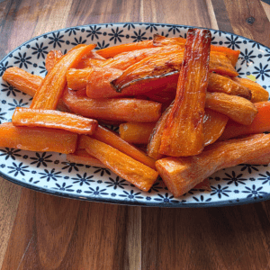 roasted carrot sticks served on a blue and white plate
