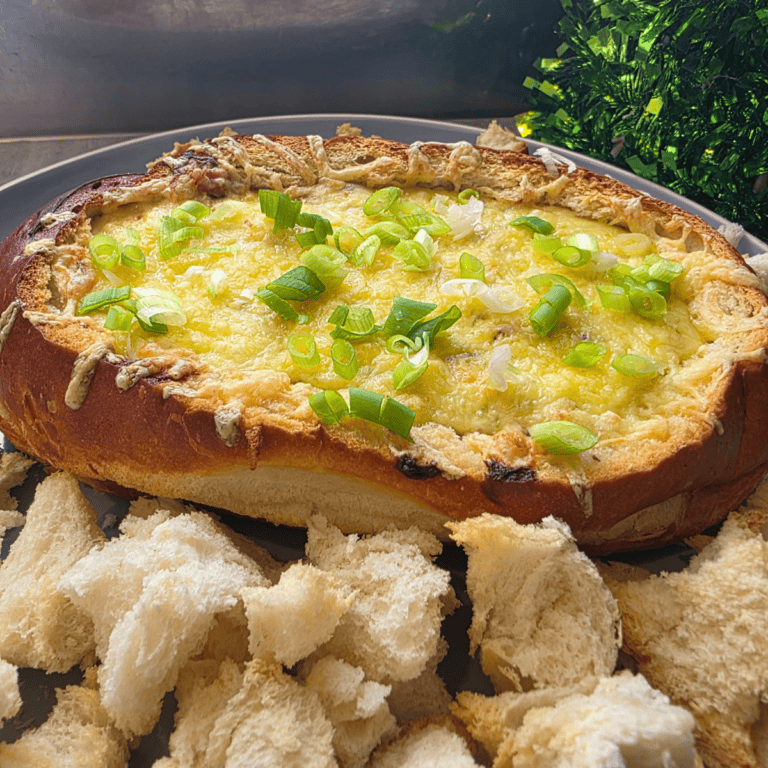 an oval cob loaf with a creamy, warm dip. dipping bread on the side