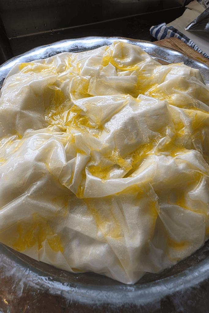 chicken mushroom with spinach filo pie, uncooked with melted butter over the pastry