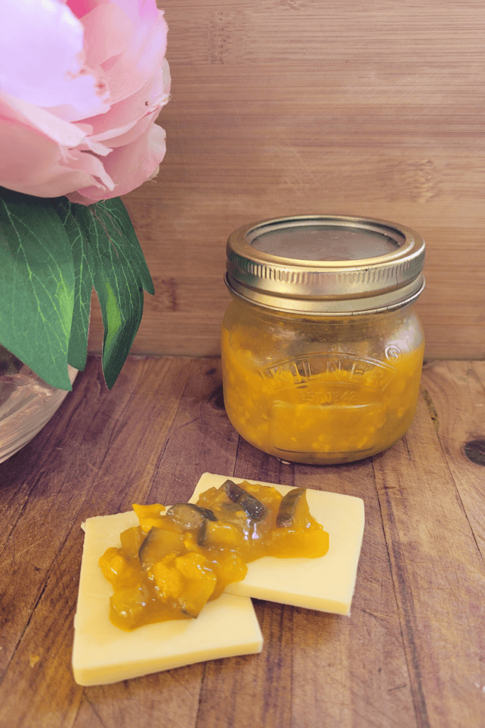 piccalilli on top of some cheese slices with the jar in the back ground