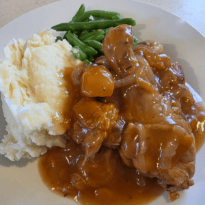 Apricot chicken served with mashed potatoes and green beans